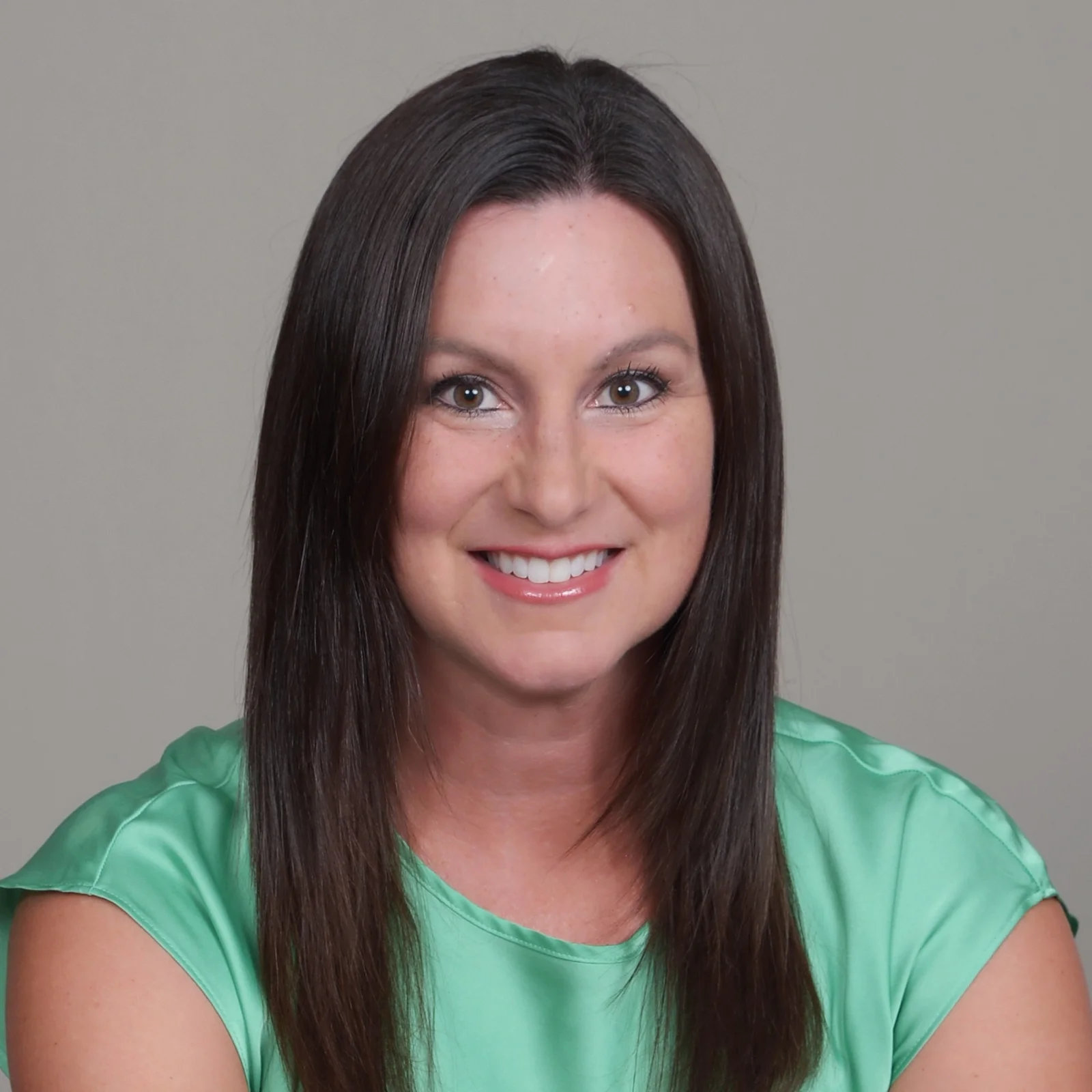 A woman with long dark hair in a green shirt, Audra Guthrie, Chief Revenue Officer at ICON Consultants.